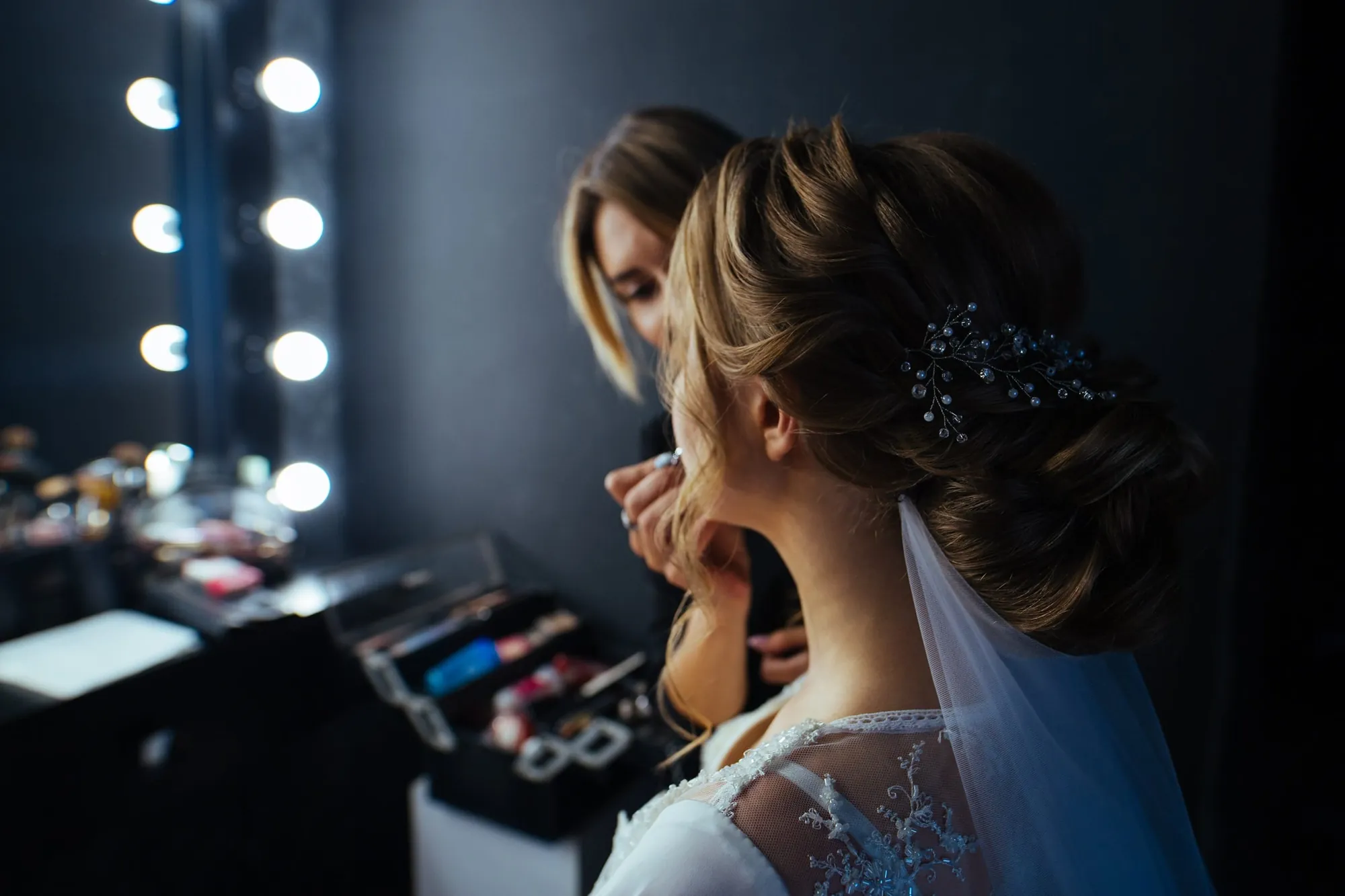 Bride with an elegant updo getting ready at the vanity