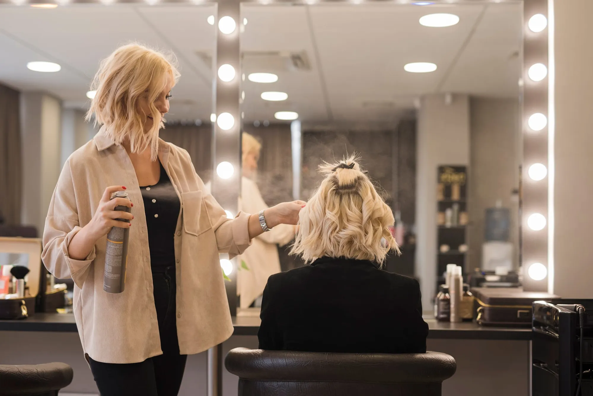 Stylist finishing a blonde blowout at New Design Unisex salon in Coral Way, Miami