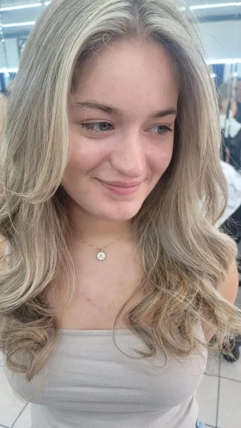 Client with soft blonde balayage waves done at New Design Unisex