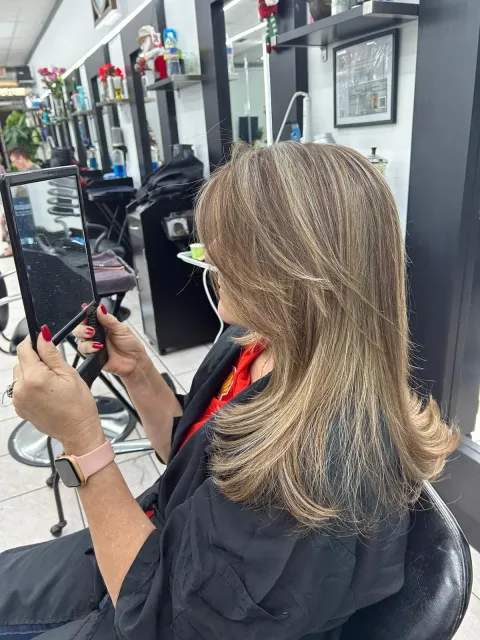 Client checking her new hair color in the salon chair